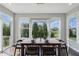 Bright dining room featuring wood floors, large windows, and a stylish chandelier above a wooden table set for four at 2485 Alexandra Dr, Carmel, IN 46074