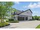 Spacious driveway leading to a three-car garage, framed by manicured landscaping and a verdant lawn at 2485 Alexandra Dr, Carmel, IN 46074