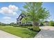 Charming two-story house showcasing a lush green lawn, landscaped bushes, and a mature shade tree at 2485 Alexandra Dr, Carmel, IN 46074