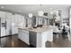 Kitchen island with seating, granite countertops, stainless dishwasher, and white cabinets overlooking living room at 2485 Alexandra Dr, Carmel, IN 46074