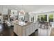 Open concept kitchen island with stainless dishwasher, seating and granite countertops overlooking living and dining areas at 2485 Alexandra Dr, Carmel, IN 46074
