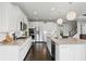 White kitchen with stainless appliances, granite countertops, gas range, and dark wood floors at 2485 Alexandra Dr, Carmel, IN 46074