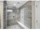 Close-up of a glass-enclosed shower with gray tiling, a built-in bench, and multiple shower heads at 2485 Alexandra Dr, Carmel, IN 46074