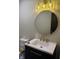 Bathroom with large round mirror, brass fixtures, and black vanity at 258 Riverwood Dr, Noblesville, IN 46062