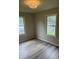 Bedroom with neutral paint, new vinyl flooring, and two windows at 258 Riverwood Dr, Noblesville, IN 46062