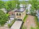 Aerial view of a home with a flat roof, attached garage, driveway, lush landscaping, and lakeside setting at 2841 Tropical Dr, Indianapolis, IN 46205