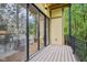 Covered balcony with sliding glass doors and black metal railings, offering views of lush greenery at 2841 Tropical Dr, Indianapolis, IN 46205
