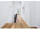 Bright hallway with hardwood floors, white walls, black metal railing, and access to the upper floors at 2841 Tropical Dr, Indianapolis, IN 46205