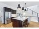 Kitchen featuring dark cabinets, quartz countertops, stainless steel appliances, and an adjacent staircase at 2841 Tropical Dr, Indianapolis, IN 46205