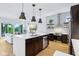 Open-concept kitchen with stainless steel appliances, dark cabinets, quartz countertops, and views into the living area at 2841 Tropical Dr, Indianapolis, IN 46205