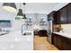 Bright kitchen featuring dark cabinets, quartz countertop, stainless steel appliances and fixtures, and light wood floors at 2841 Tropical Dr, Indianapolis, IN 46205