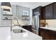 Modern kitchen with dark wood cabinets, white countertops, stainless steel appliances, and open shelving at 2841 Tropical Dr, Indianapolis, IN 46205