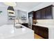 Well-equipped kitchen featuring stainless steel appliances, dark cabinets, white quartz countertops, and wooden floors at 2841 Tropical Dr, Indianapolis, IN 46205