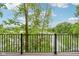 Beautiful lake views are seen through a black metal safety fence and lush trees under a partly cloudy sky at 2841 Tropical Dr, Indianapolis, IN 46205