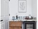 Wet bar features granite countertop, wood cabinetry, beverage fridge, and modern decor at 2841 Tropical Dr, Indianapolis, IN 46205