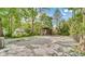 Backyard featuring a gravel area with trees and greenery surrounding the home at 3106 N Harding St, Indianapolis, IN 46208