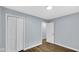 Spacious bedroom with wood-look flooring, light-blue walls, closet and adjacent doorway at 3106 N Harding St, Indianapolis, IN 46208