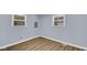 Bright bedroom with wood-look floors, light-blue walls, and two windows providing natural light at 3106 N Harding St, Indianapolis, IN 46208