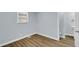 Well-lit bedroom featuring wood-look floors, light-blue walls, and adjacent bathroom at 3106 N Harding St, Indianapolis, IN 46208