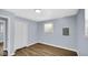 Bedroom with wood-look flooring, light-blue walls, closet, and ample natural light from a window at 3106 N Harding St, Indianapolis, IN 46208