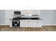 Kitchen features stainless steel appliances, granite countertops, and modern white cabinetry with sleek hardware at 3106 N Harding St, Indianapolis, IN 46208