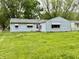 A view of the backyard of this home showing a grassy yard and the back of the house at 3325 Canaday Dr, Anderson, IN 46013