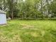 A view of the large backyard showing grass, trees, a shed and the back of the house at 3325 Canaday Dr, Anderson, IN 46013