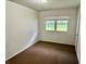 This bedroom has neutral colored walls, carpet and a window looking out to the yard at 3325 Canaday Dr, Anderson, IN 46013