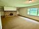 A spacious living room features carpeted floors and a brick fireplace at 3325 Canaday Dr, Anderson, IN 46013