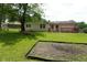 A spacious backyard, featuring a red deck, and mature trees at 3612 Carolee Ct, Indianapolis, IN 46227