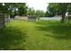 Spacious backyard featuring lush green grass, mature trees, and several storage sheds at 3612 Carolee Ct, Indianapolis, IN 46227