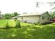 A well-maintained backyard with green grass and a brick exterior, featuring a chainlink fence and deck at 3612 Carolee Ct, Indianapolis, IN 46227