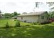 A well-maintained backyard with green grass and a brick exterior, featuring a chainlink fence and deck at 3612 Carolee Ct, Indianapolis, IN 46227
