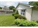 Well-maintained backyard featuring a lush green lawn, mature shrubs, and white brick at 3612 Carolee Ct, Indianapolis, IN 46227