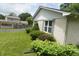 Well-maintained backyard featuring a lush green lawn, mature shrubs, and white brick at 3612 Carolee Ct, Indianapolis, IN 46227
