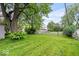 A spacious backyard is framed by mature trees and a wooden fence, offering a private outdoor oasis at 3801 N Vernon Dr, Muncie, IN 47304