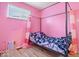 A cozy pink bedroom features a unique four-poster bed and light wood flooring, creating a whimsical atmosphere at 3801 N Vernon Dr, Muncie, IN 47304