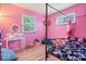 Bright pink bedroom featuring windows and hardwood floors at 3801 N Vernon Dr, Muncie, IN 47304