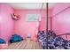 A pink bedroom includes a fun stuffed animal hammock and a unique four-poster bed, creating a playful space at 3801 N Vernon Dr, Muncie, IN 47304