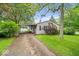 Single-story home with driveway and carport nestled on a well-maintained lawn with mature landscaping at 3801 N Vernon Dr, Muncie, IN 47304