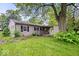 Single-story home with driveway and carport nestled on a well-maintained lawn with mature landscaping at 3801 N Vernon Dr, Muncie, IN 47304