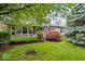 Charming single-story home featuring a lush front yard with mature trees and colorful landscaping at 3801 N Vernon Dr, Muncie, IN 47304