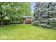 Charming single-story home featuring a lush front yard with mature trees and colorful landscaping at 3801 N Vernon Dr, Muncie, IN 47304