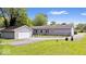 A view of the backyard with a detached garage, green grass, and a chainlink fence at 4244 Asbury St, Indianapolis, IN 46227