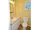 Bright bathroom with a toilet, sink, vanity with a marble countertop, and a window at 4675 N Herbemont Rd, Martinsville, IN 46151