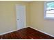 Neutral bedroom shows hardwood floors, door, and a window with natural light at 4675 N Herbemont Rd, Martinsville, IN 46151