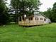 The home offers a large, inviting wooden deck surrounded by lush green landscaping and mature trees at 4675 N Herbemont Rd, Martinsville, IN 46151