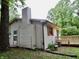 Exterior view of home with siding, a wood deck, chimney, and lush green trees surrounding the property at 4675 N Herbemont Rd, Martinsville, IN 46151