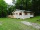 This image displays a single Gathering home with wood siding, green grass, and a deck at 4675 N Herbemont Rd, Martinsville, IN 46151