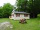 Exterior view of home with wood siding, shutters, and a well-manicured lawn surrounded by mature trees at 4675 N Herbemont Rd, Martinsville, IN 46151